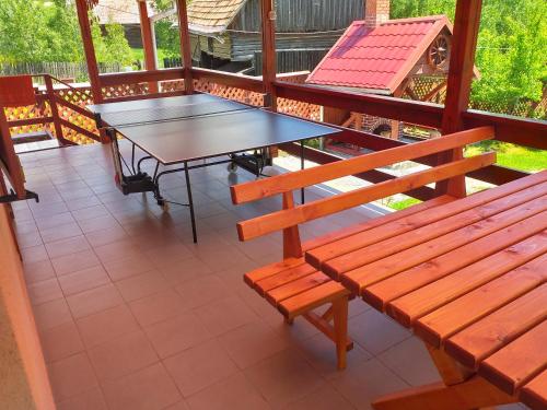 a table and a bench on a balcony at Szarvas Vendeghaz in Izvoru Mureşului