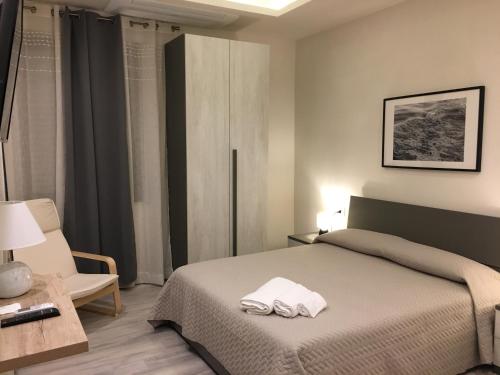 una camera da letto con un letto e due asciugamani di Dimora Conte a La Maddalena