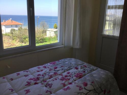 a bedroom with two windows and a bed with flowers at Yalova Apartments in Yalova