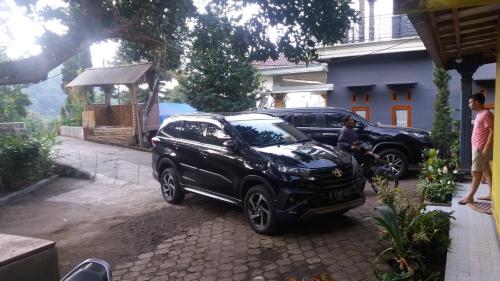 a black suv parked in front of a house at Budhis Home in Bromo