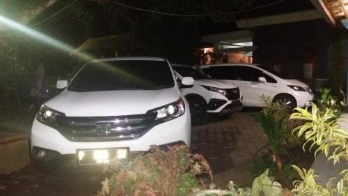 two cars parked in a parking lot at night at Budhis Home in Bromo