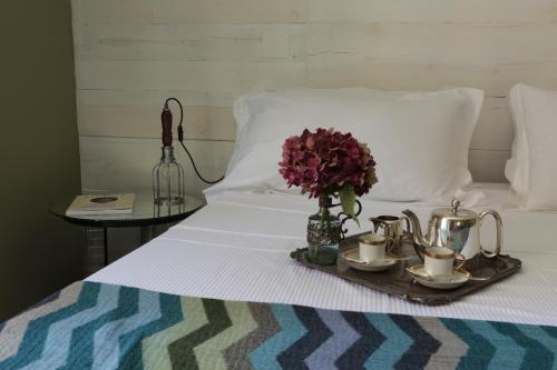 a tray with tea pots and flowers on a bed at Hotel Blu di Te in Santa Margherita Ligure