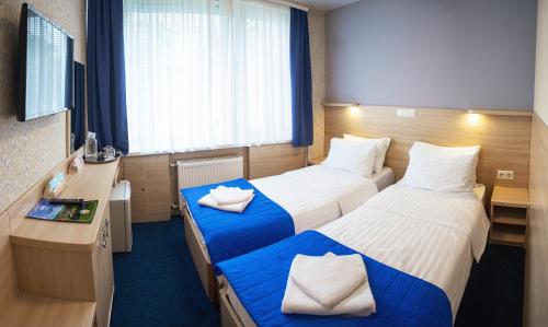 a hotel room with two beds and a desk at Truskavets 365 Hotel in Truskavets