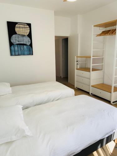 two beds in a room with white walls at ALPS COCOON in Annecy