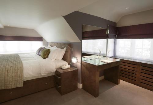 a bedroom with a large bed and a sink at The Dog and Badger in Marlow