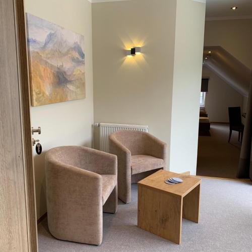 two chairs and a coffee table in a room at Weinbergs Loge in Ernst