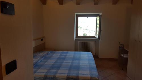 Schlafzimmer mit einem Bett und einem Fenster in der Unterkunft Casa Luisa in Brenzone sul Garda
