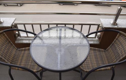 a table and two chairs with a table and a glass table at Apartmani Marić in Novi Pazar