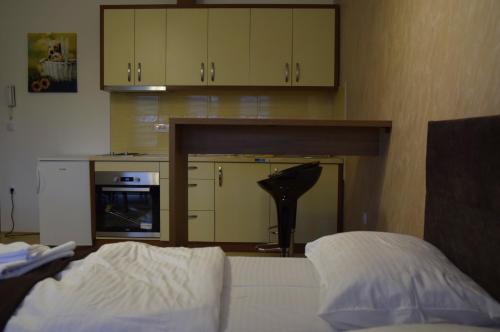 a bedroom with a bed and a kitchen with cabinets at Apartmani Marić in Novi Pazar