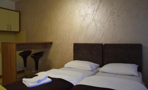 a bedroom with two beds with white pillows at Apartmani Marić in Novi Pazar