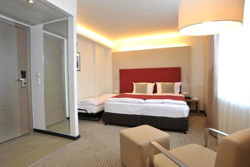 Postel nebo postele na pokoji v ubytování Golden Tulip Kassel Hotel Reiss