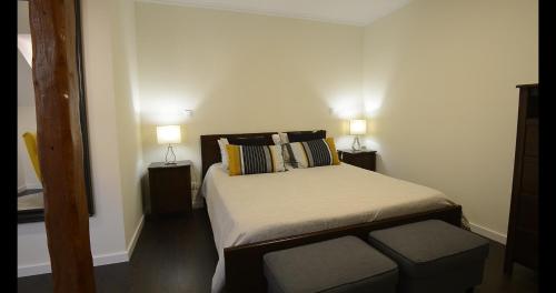 a small bedroom with a bed and two lamps at Casa da Matriz in Ponta Delgada