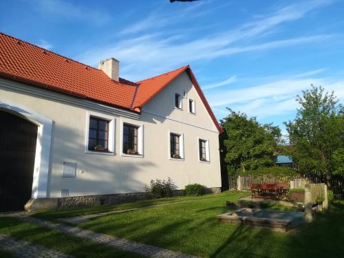 Casa blanca con techo rojo y patio en Usedlost pod javorem, en Telč