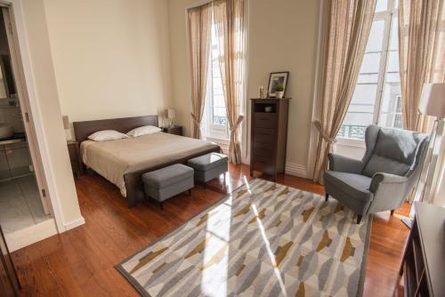 a bedroom with a bed and a chair at Casa da Matriz in Ponta Delgada