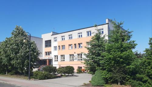 an apartment building with trees in front of it at Centrum Konferencyjne Brancon in Babimost