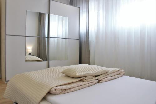 a white bedroom with a bed with a mirror at Ferienwohnung in Zweibrücken