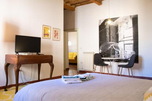 a bedroom with a bed and a desk with a television at Silviù in Perugia