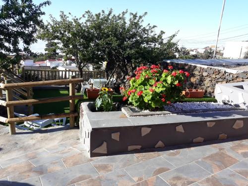 a garden with flowers and a stone wall at Casa rural meridiano in El Pinar del Hierro