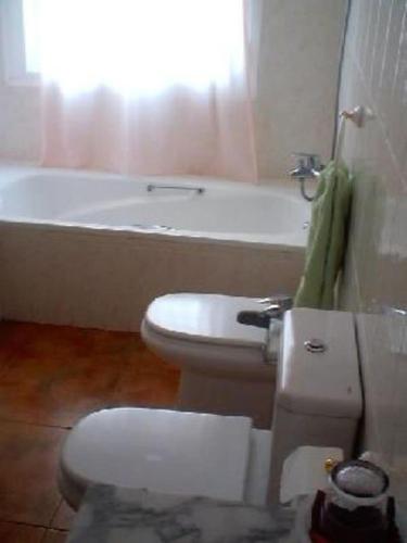 a bathroom with a toilet and a bath tub at Casa El Algarrobico in Agua Amarga