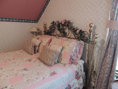 a bedroom with a bed with a floral bedspread at Brookview Manor Inn in Canadensis