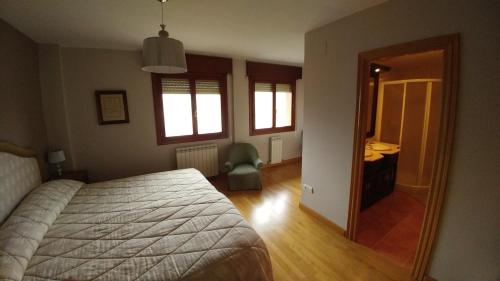 a bedroom with a bed and a desk and a mirror at El Mirador de Molinos in Molinos de Duero