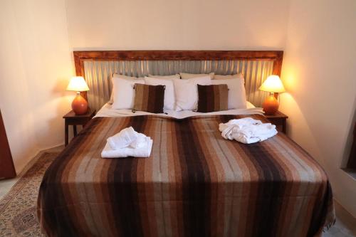 a bedroom with a large bed with towels on it at Casa Colonial Koenig in São Filipe