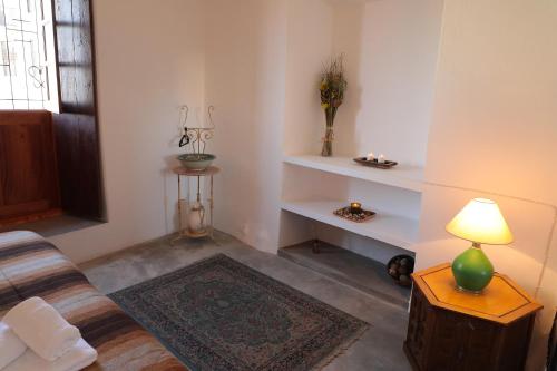 a living room with a couch and a table with a lamp at Casa Colonial Koenig in São Filipe