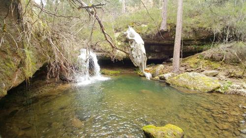 a pool of water in a creek with a waterfall at El Mirador de Molinos in Molinos de Duero