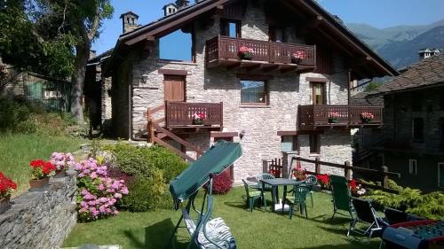 a house with a table and chairs in the yard at Maison d'Antan in Introd