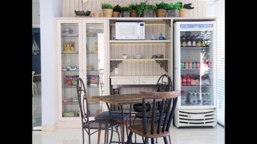 ein Tisch und Stühle vor einem Kühlschrank in der Unterkunft Aracaju Corais Hotel in Aracaju