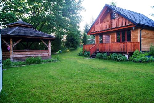 a log cabin with a gazebo in a yard at Chrząszczewo Widokowe wzgórze 1 in Uherce Mineralne