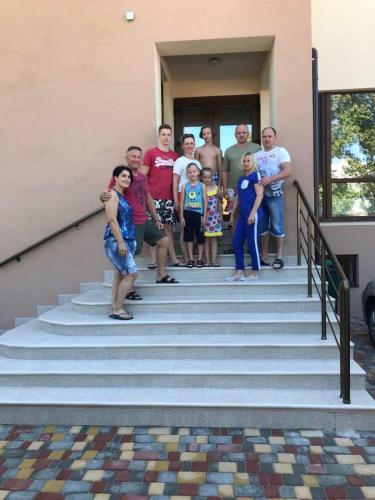 a group of people standing on the steps of a house at Villa San-Marina in Zatoka