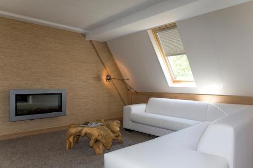 a living room with a couch and a tv at Van der Valk Hotel Arnhem in Arnhem