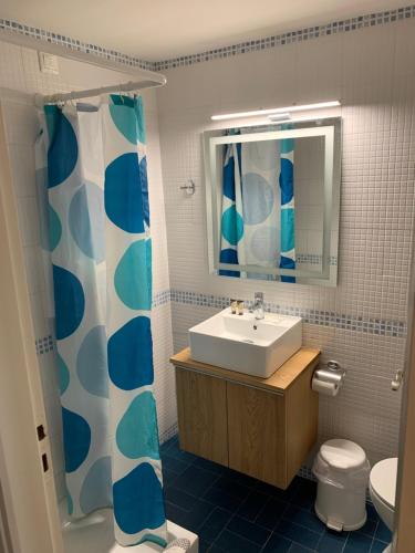een badkamer met een wastafel, een toilet en een spiegel bij Nancy Hotel in Chersonissos