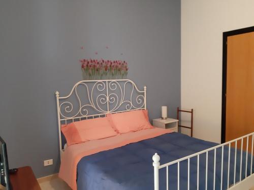 - une chambre avec un lit doté d'une couverture bleue et d'oreillers roses dans l'établissement Arifra, à Pulsano
