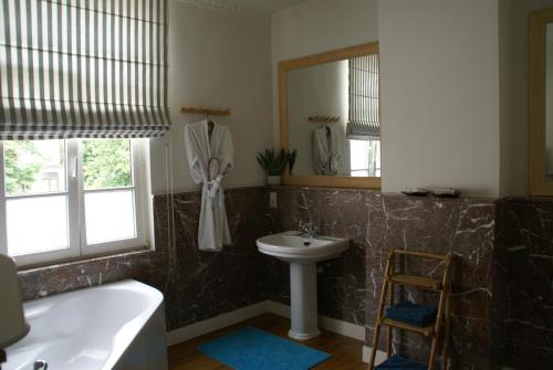 a bathroom with a tub and a sink and a mirror at Au Coeur de la Famille in Knokke-Heist