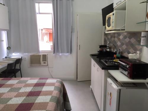 a small room with a bed and a kitchen at Cosy studio in Copacabana in Rio de Janeiro