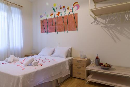 a bedroom with a white bed with flowers on it at Eco Villa in Mákri