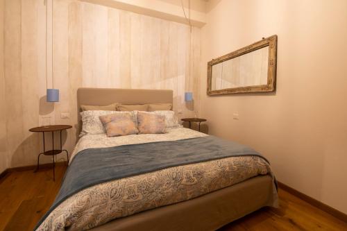 Casa Vacanze Gombito 4 Bergamo Alta في بيرغامو: غرفة نوم بسرير كبير ومرآة