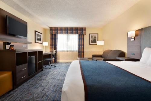 a hotel room with a bed and a television at Ramada by Wyndham Spokane Airport in Spokane