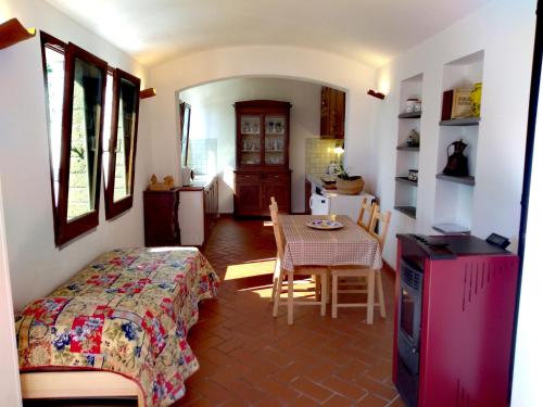 a bedroom with a bed and a table and a kitchen at ROMANTICA TOSCANA in Scarlino