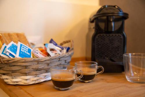 two cups of coffee on a table with a basket of food at Casa Vacanze Gombito 4 Bergamo Alta in Bergamo