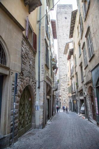 an alley with buildings and people walking down a street at Casa Vacanze Gombito 4 Bergamo Alta in Bergamo