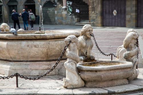 a fountain with two statues of dogs chained to it at Casa Vacanze Gombito 4 Bergamo Alta in Bergamo