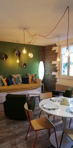 un salon avec un canapé, des tables et des chaises dans l'établissement Gîte, le Colmar Vintage Station, à Colmar