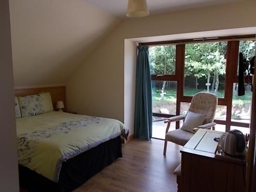 a bedroom with a bed and a desk and a window at Forest View in Fraserburgh