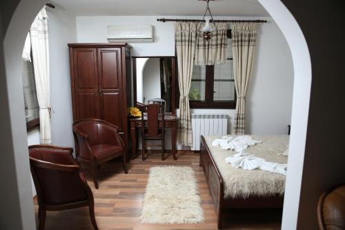 a bedroom with a bed and a table and chairs at Oazis Guesthouse in Lovech