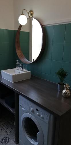 La salle de bains est pourvue d'un lave-linge et d'un miroir. dans l'établissement Gîte, le Colmar Vintage Station, à Colmar