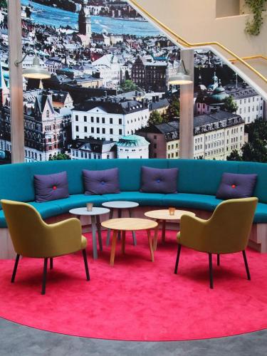a blue couch in a room with tables and chairs at ProfilHotels Central in Stockholm