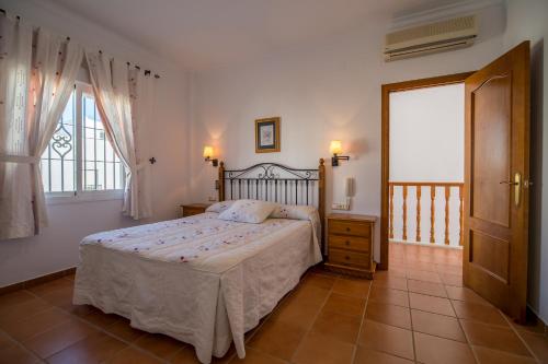 sypialnia z łóżkiem i oknem w obiekcie Chalet adosado Atalaya P w mieście Conil de la Frontera